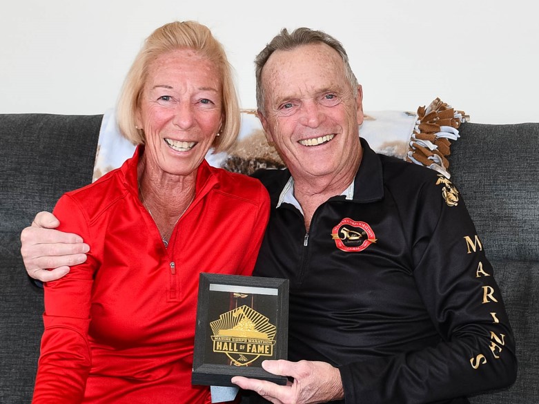 man and woman sitting together holding plaque