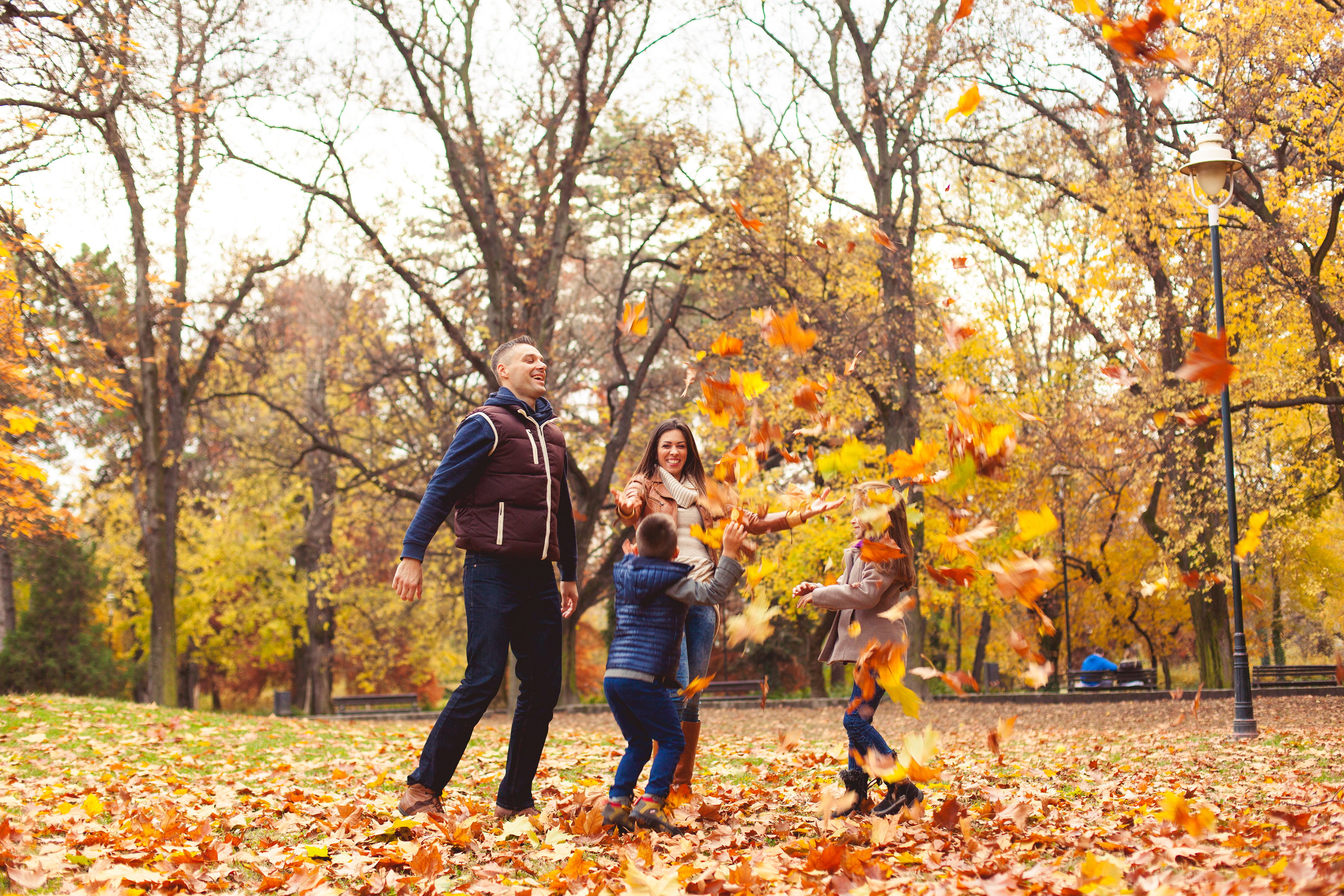 Family playing in fall leaves